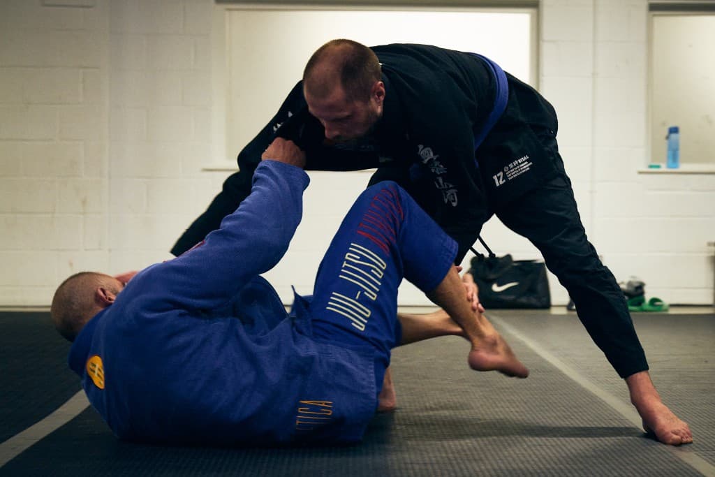 Two Jiu Jitsu practitioners sparring on the mats