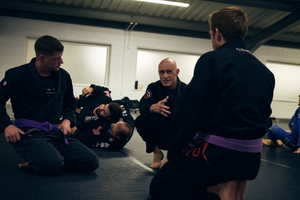 Instructor teaching Brazilian Jiu Jitsu on the mats